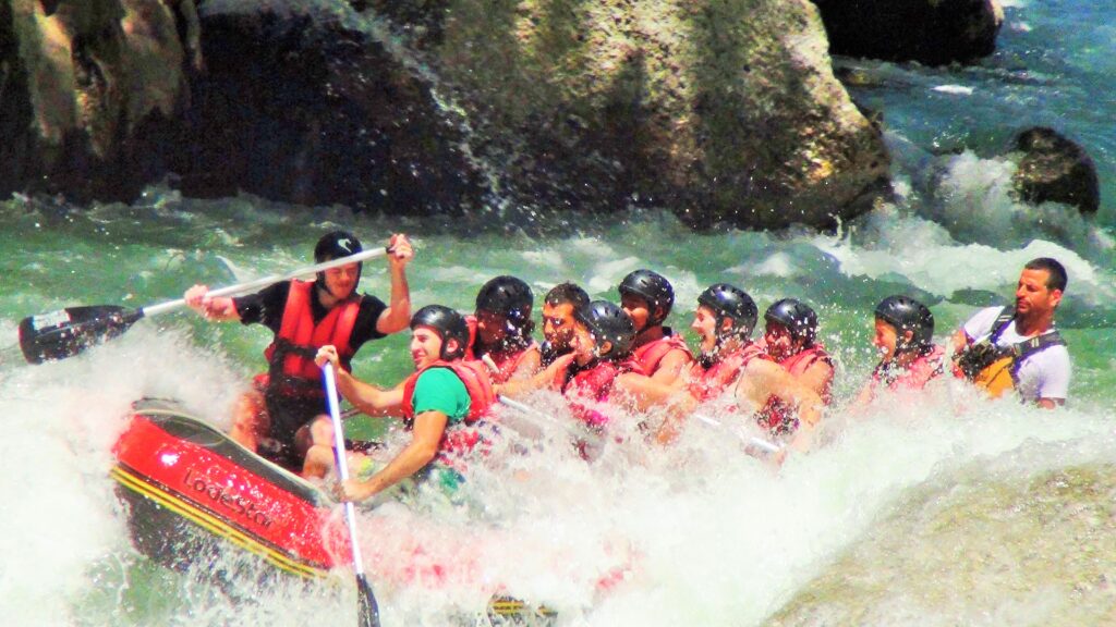 Nehirdeki rafting turunda, maceraperestler suyun hızına ayak uydururken görülür.